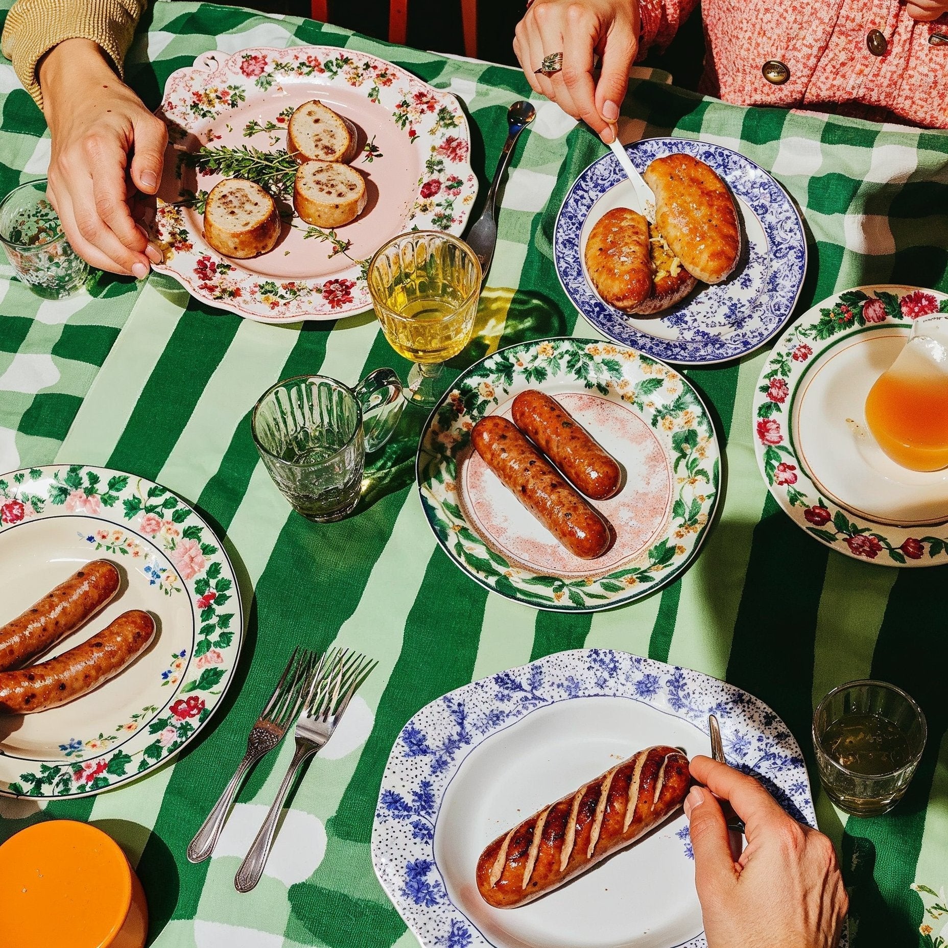 magnific-kmHnciQQm32jm4t8ZPS8-u2678577971_A_table_set_with_sausages_plates_and_glasses_on_g_0d611cc5-8008-4806-8045-974287275d84_1.jpg